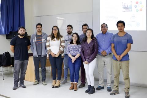 Un grupo de ocho personas posan juntas en un aula.