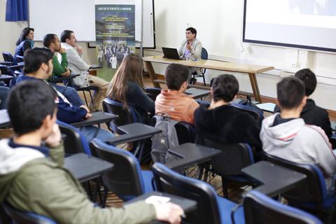 Una persona está presentando frente a un grupo de estudiantes en un aula.