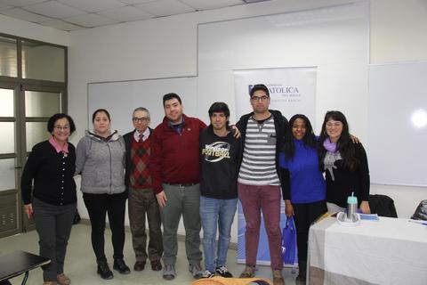 Grupo de personas posando en una sala de clases.