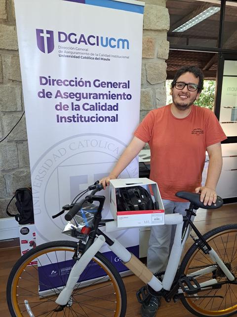 Una persona sonriente sostiene una bicicleta con un casco en un entorno de oficina.