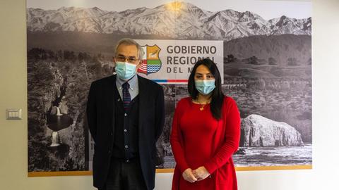 Dos personas posan frente a un fondo con paisajes montañosos y el logo del Gobierno Regional.