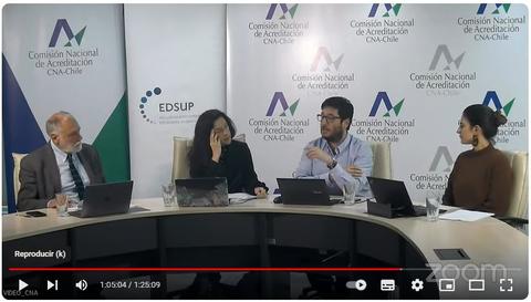 Una reunión de varias personas discutiendo en una mesa con computadoras portátiles.