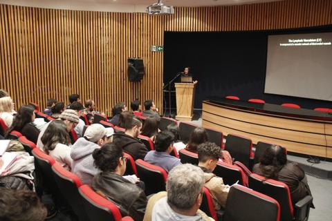 Una conferencia se lleva a cabo en un auditorio con público atento.