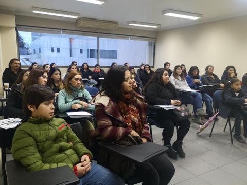 Un grupo de personas sentadas en un aula durante una presentación.