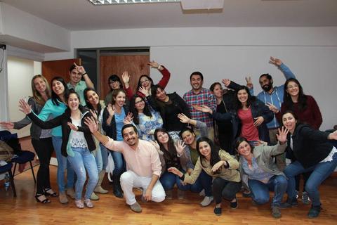 Un grupo de personas sonrientes se reúne en una sala, mostrando una actitud divertida y alegre.