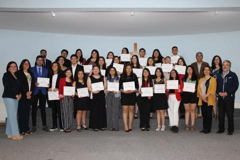 Grupo de personas con certificados en un evento de graduación.