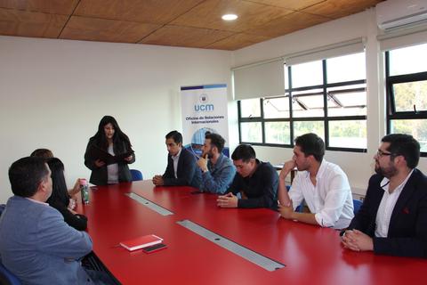 Reunión de profesionales en una sala de conferencias con una persona presentando.