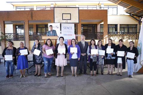 Un grupo de mujeres recibe certificados en un evento al aire libre.