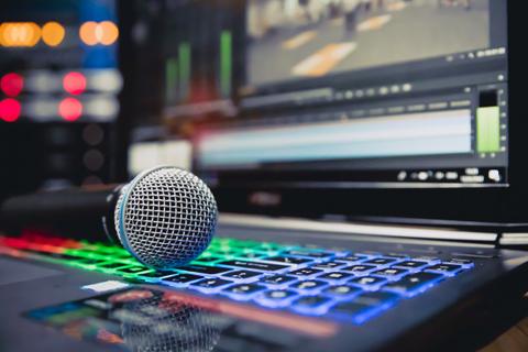 Una computadora portátil con un micrófono sobre el teclado iluminado.