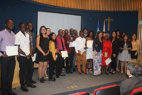 Un grupo de personas posando en un evento de graduación con certificados en mano.