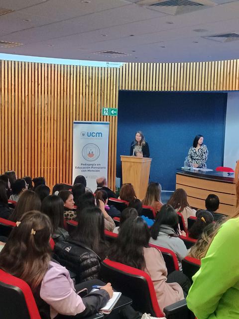 Una presentación en un seminario con varios asistentes en un auditorio.