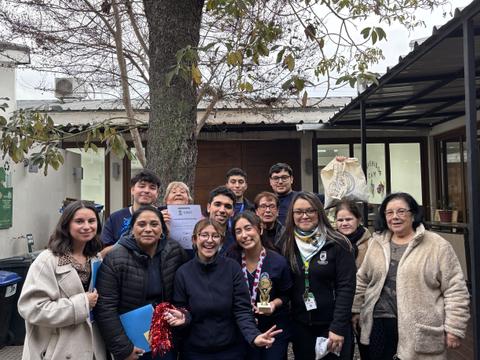 Un grupo de personas sonrientes celebra un logro en un encuentro comunitario.