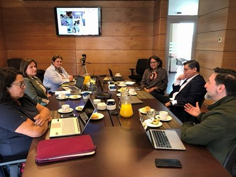 Una reunión en la que participan varias personas discutiendo temas importantes en un ambiente profesional.