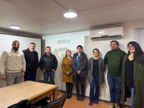 Un grupo de personas posando en una oficina después de una reunión.
