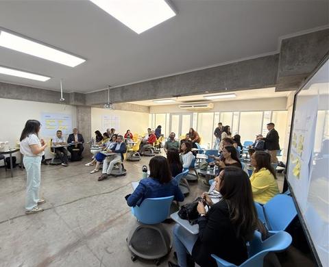 Un grupo grande de personas participando activamente en una sesión de trabajo colaborativo.