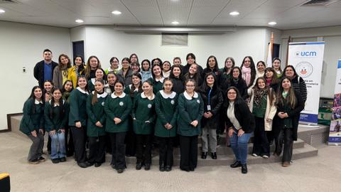 Un grupo de estudiantes y profesores posando juntos en un evento en la universidad.