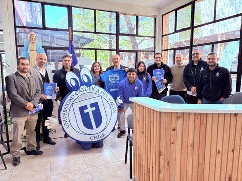 Un grupo de personas se reúne en la Universidad Católica del Maule, posando junto a una mascota institucional.