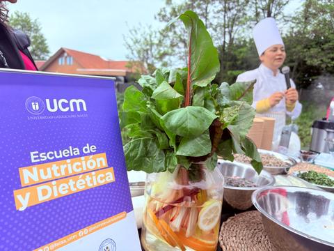 En la imagen se observa un hermoso arreglo de verduras frescas junto a un chef hablando sobre nutrición.