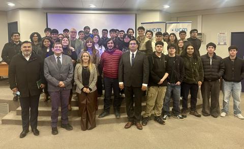 Un grupo de estudiantes y profesores posando juntos en un evento académico.
