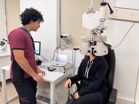 Un profesional de la salud visual está midiendo la visión de una paciente en un consultorio.