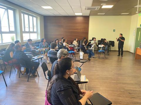 Un grupo de personas participando en una clase o taller en un aula.