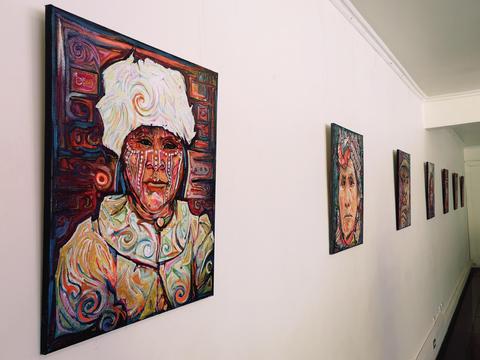 La imagen muestra una galería con varios retratos de estilo artístico expuestos en la pared.