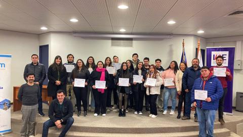 Un grupo de personas posando con certificados en un evento de entrega de reconocimientos.