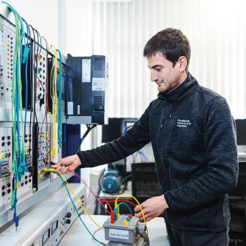 Un joven ingeniero trabajando en un laboratorio con equipos electrónicos.