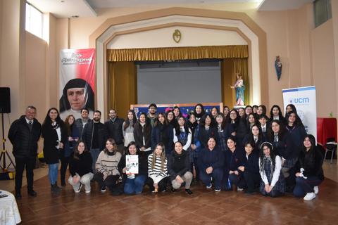 Un grupo numeroso de personas posando en un evento en un auditorio.