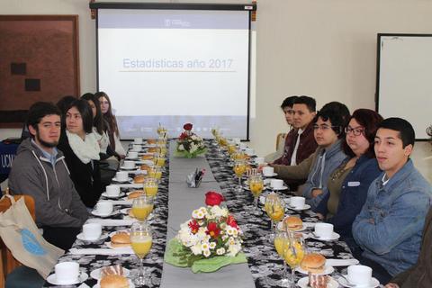 Un grupo de personas sentadas alrededor de una mesa decorada con flores y desayunos en un evento relacionado con estadísticas.