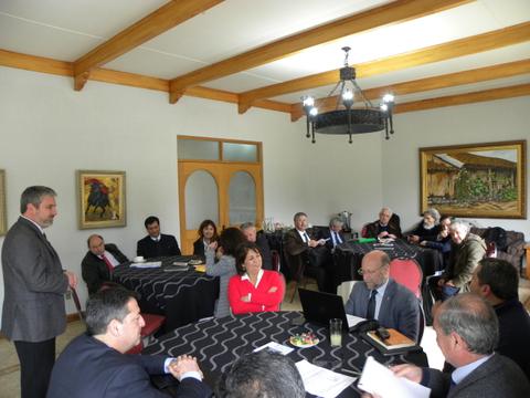 Una reunión de un grupo de personas sentadas alrededor de mesas en un ambiente de oficina.
