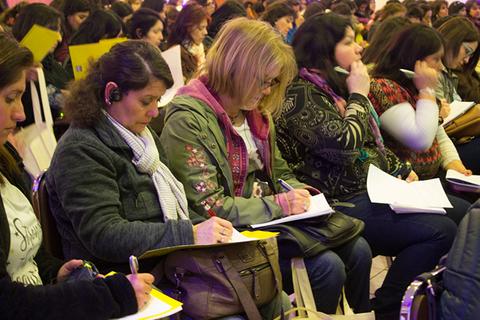 Un grupo de mujeres participantes en un evento tomando notas.