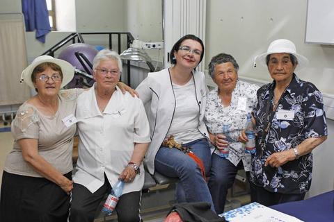 Un grupo de cinco mujeres sonrientes posando juntas en un ambiente amigable.