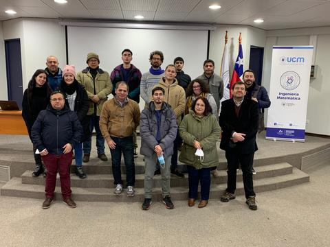 Un grupo de personas sonrientes se reúne en un evento en un auditorio.