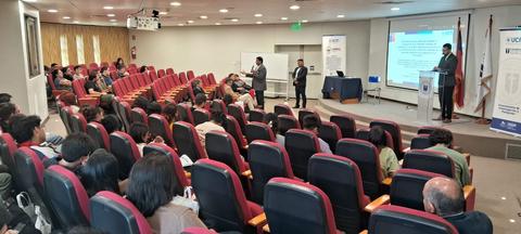 Una conferencia con un público atento en un auditorio moderno.