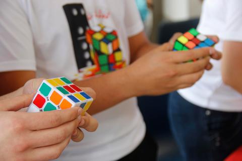 Un grupo de personas sostiene cubos de Rubik en un ambiente social.