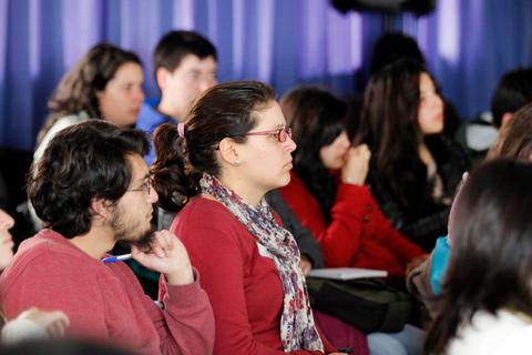 Un grupo de jóvenes escuchando atentamente durante una presentación.
