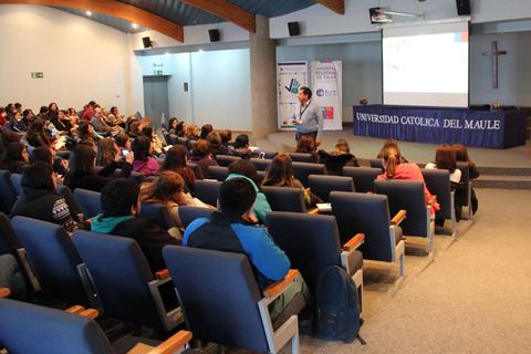 Un profesor presenta frente a un auditorio lleno de estudiantes en una universidad.