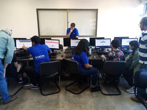 Un grupo de personas trabaja frente a computadoras en un ambiente de oficina.