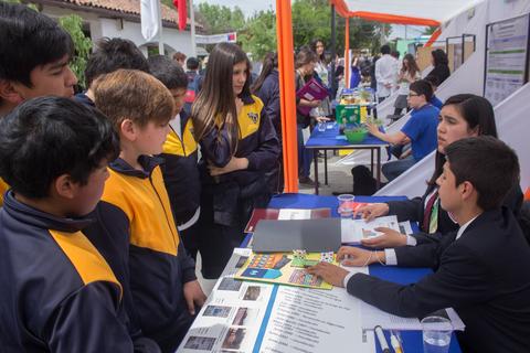 Un grupo de estudiantes presenta proyectos en una feria de ciencias.