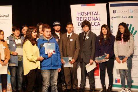 Un grupo de jóvenes en un evento, algunos sosteniendo certificados y otros en traje formal.