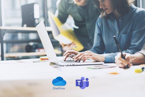 Dos personas trabajan colaborativamente en una oficina moderna utilizando una computadora portátil.