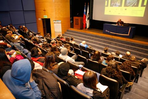 Una audiencia atenta participa en una conferencia en un auditorio.