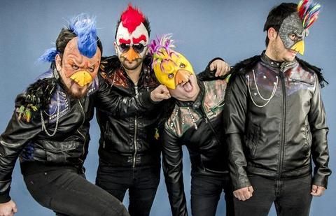 Un grupo de cuatro personas con trajes de cuero y máscaras de aves posan en una fotografía divertida.