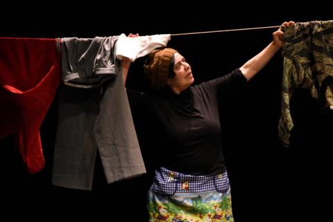 Una mujer cuelga ropa en un tendedero, mostrando su dedicación al quehacer diario.