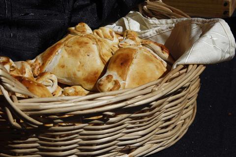 Una cesta con empanadas doradas recién horneadas.