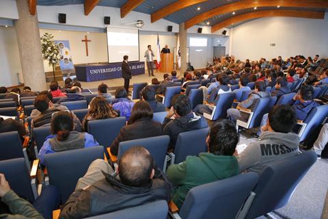 Una conferencia en una universidad con numerosos asistentes sentados en un auditorio.