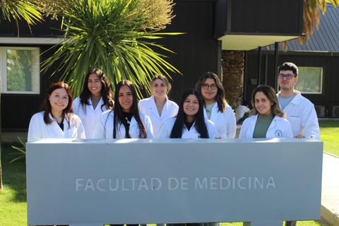 Grupo de estudiantes de medicina posando frente a la Facultad de Medicina.