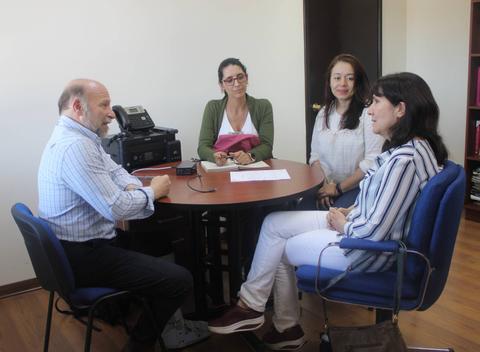 Un grupo de cuatro personas conversando en una oficina.