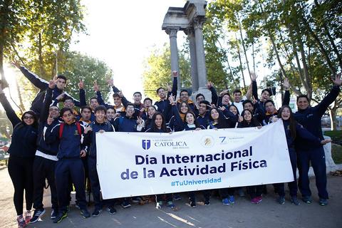 Un grupo de personas celebra el Día Internacional de la Actividad Física, levantando un cartel conmemorativo.